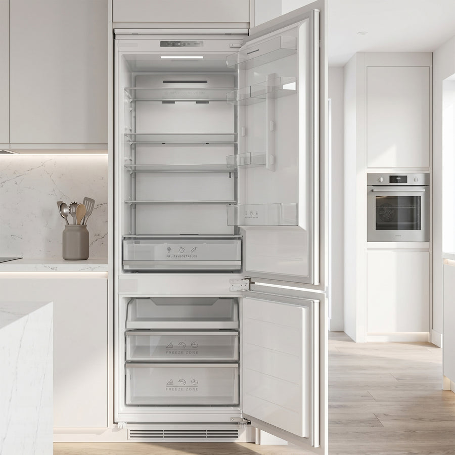 Heinner HCNF-BIM403INVD inbouw koel-vriezer in moderne witte keuken met geopende deur toont koelkast- en vriesgedeelte.